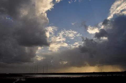 Sky with wild clouds reflected on them by the sun Stock-Fotos