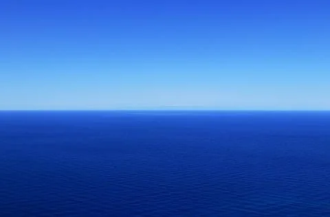 Sky without clouds with changing shades of blue and dark mediterranean sea. I Stock Photos
