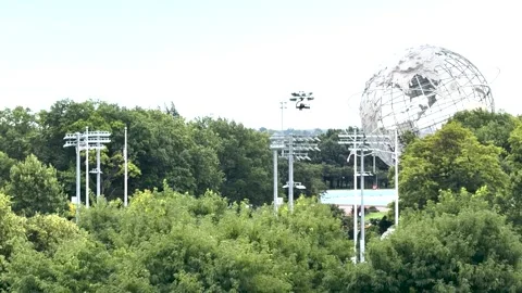 SKYCAM GLIDING IN FRONT OF 1964 WORLD'S FAIR LANDMARKS AT FLUSHING MEADOWS Stock Footage 343868449