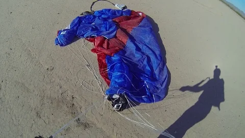 A skydiver adjusts her equipment after parachuting. Stockbeeldmateriaal 71249912