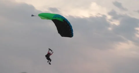 Skydiver with green parachute lands in crowd Stock Footage 166326838