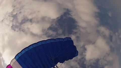 Skydiver in helmet parachuting in cloudy sky. Height. Extreme sport. Speed. Видео 79512408