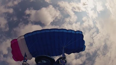 Skydiver in helmet parachuting in cloudy sky. Height. Extreme hobby. Speed. Video stock 79512626