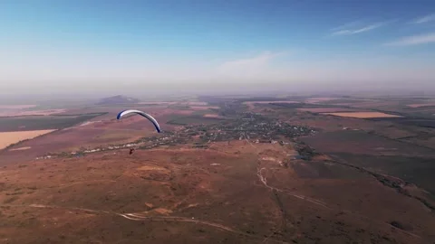 Skydiver hovers weightless above the ground after taking off from the fields. A 動画素材 267967077