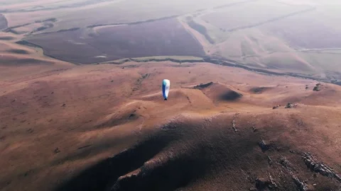 Skydiver hovers weightless above the ground after taking off from the fields. A 動画素材 267967592