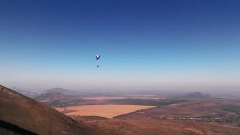 Skydiver hovers weightless above the ground after taking off from the fields. A 動画素材 267968083