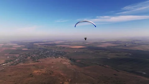 Skydiver hovers weightless above the ground after taking off from the fields. A 動画素材 270084762