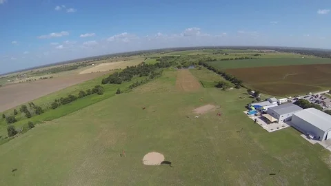 A skydiver landing after parachuting to the ground. Stockbeeldmateriaal 71249987