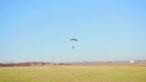 Skydiver lands in a field Stock Footage 145973175