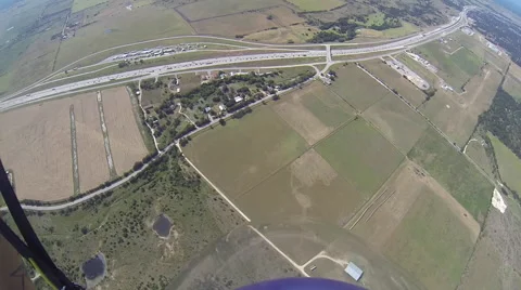 A skydiver looks at her altimeter while parachuting. Видео 68010015