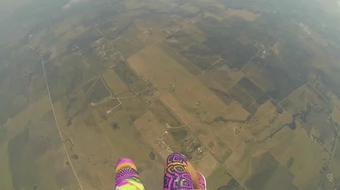 A skydiver looks at her altimeter while parachuting. 스톡 동영상 68010019