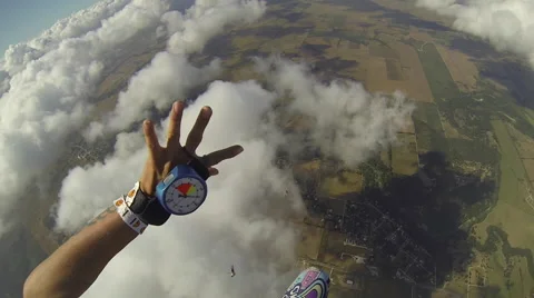 A skydiver looks at her altimeter while parachuting. 스톡 동영상 68010083