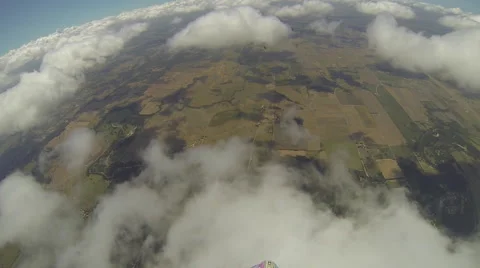 A skydiver looks at her altimeter while parachuting. 스톡 동영상 68010092
