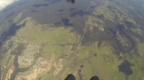 A skydiver looks at her altimeter while parachuting. 스톡 동영상 68010315