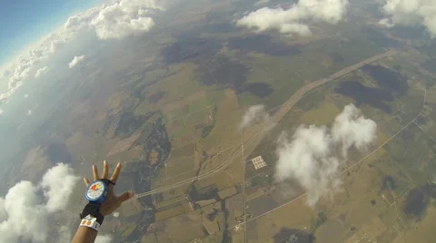 A skydiver looks at her altimeter while parachuting. Stock Footage 68573054