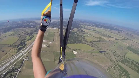 A skydiver looks at her altimeter while parachuting. Stock Footage 71248467