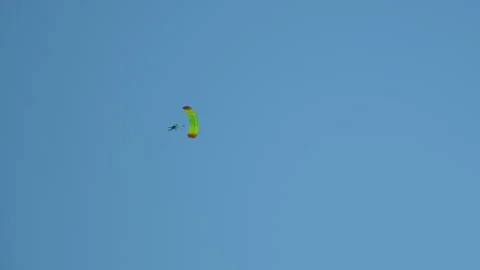 Skydiver man person gliding on an opened parachute for a controlled Stock Footage 244913396