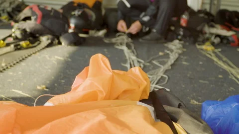 Skydiver organizing ropes and preparing parachutes for folding and packing Video stock 244910869