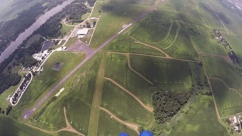 Skydiver parachuting above green fields. Extreme sport activity. Adrenaline Stock Footage 69966334