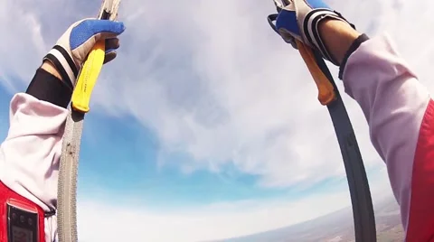 Skydiver parachuting in cloudy sky above fields. Extreme sport. Landscape Stockbeeldmateriaal 66747943