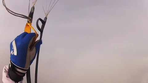 Skydiver parachuting in cloudy sky above green field. Extreme sport. Height. Видео 96442258