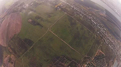 Skydiver parachuting in cloudy sky in evening above city. Extreme sport. Flight Stockbeeldmateriaal 66748141