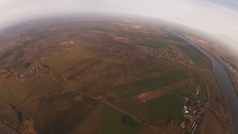 Skydiver parachuting in cloudy sky in evening above green field, city. Landscape Video stock 96444747