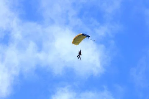 Skydiver parachuting down to the earth. Stock Photos