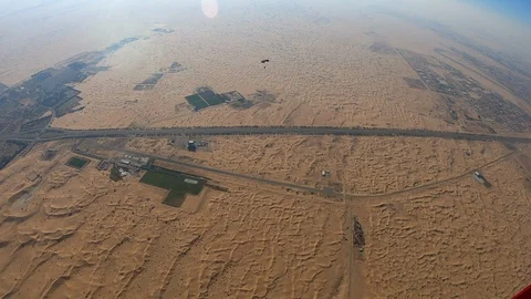 Skydiver parachuting over the desert dunes Stock Footage 101736767