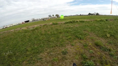 Skydiver Sails His Parachute Into an Open Green Field Stock Footage 208738257
