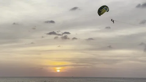 Skydiver soaring above the ocean at sunset, embodying the spirit of freedom and Stock Footage 272805133