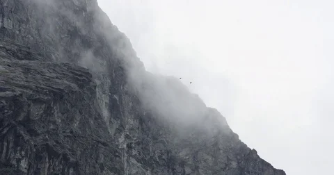 Skydivers Dive Through Clouds In Mountainscape Video stock 82274519