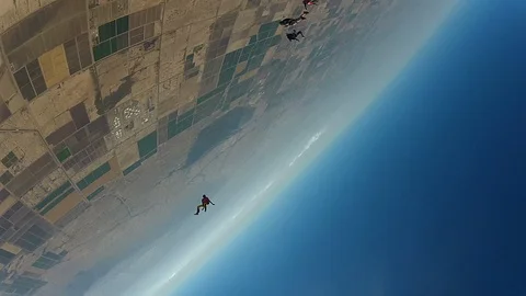 Skydivers fly in the sky on a clear day. Group of parachutist freefalling Stock Footage 91607755