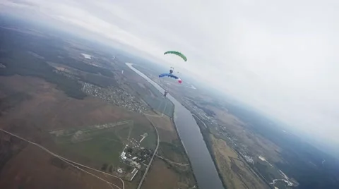 Skydivers fly in sky over green field. Colorful parachutes. Extreme. Group Stock Footage 65797747