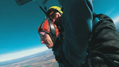 Skydivers flying in tandem under the open parachute Stock Footage 96579173