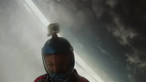 Skydivers jump from airplane in cloudy sky above land. Fog. Extreme sport. Group Stock Footage 152064889