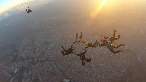 Skydivers make a formation skydive at the sunset slow motion Stockbeeldmateriaal 120482373