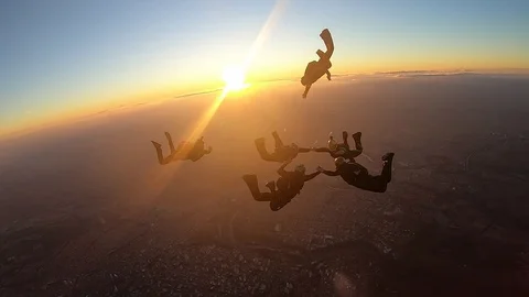 Skydivers make a formation skydive at the sunset - crash Stock Footage 120482382