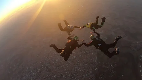 Skydivers make a formation skydive at the sunset Stock Footage 120489752