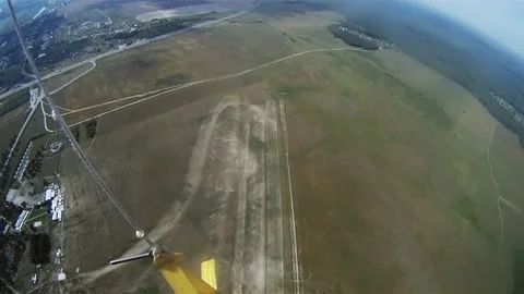 Skydivers parachuting in cloudy sky above green flatland with river, forest. Stockbeeldmateriaal 152063789