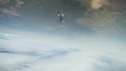 Skydivers parachuting in cloudy sky above green flatland. Extreme sport. Height Видео 152063937