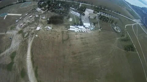 Skydivers parachuting in cloudy sky over green flatland with river. Sport. Video stock 152063842