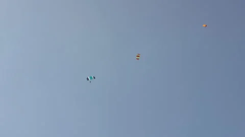 Skydivers Parachuting Gently Down Through the Blue Sky Stock Footage 208737348