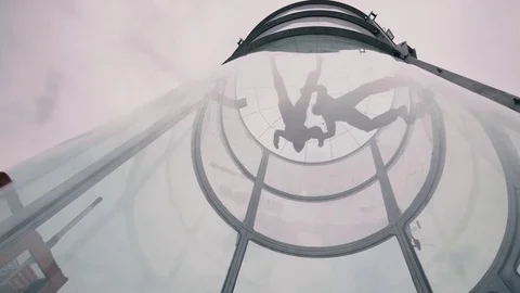 Skydivers tandem fly into wind tunnel. Extreme parachuting Stockbeeldmateriaal 77152134