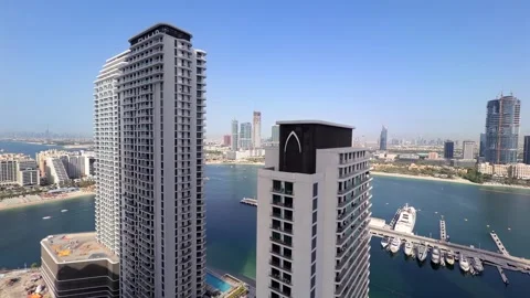Skyline perspective of Palm Jumeirah captured from Emaar Beachfront in DUbai Stock Footage 336037115