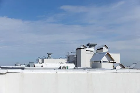 Skyline View of Modern Rooftops with Architectural Features and a Cloudy Stock Photos