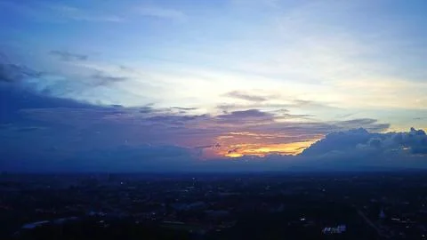Skyline view of sunset with clouds over a city landscape Stock Photos
