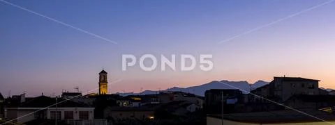 Skyline of the village of Benissanet at sunset with silhouetted mountains in the Stock Photos