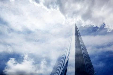 Skyscraper against cloudy sky Stock Photos