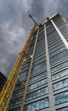 Skyscraper and the crane with dramatic sky in the background Foto stock